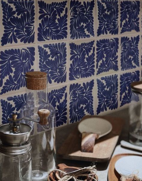 Decorative blue and white Spanish Revival tiles create a charming kitchen backsplash with rustic accessories.