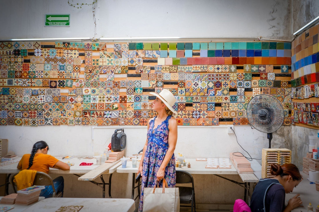Artist Amy Pigliacampo observes a vibrant Mexican tile workshop, filled with colorful patterns and busy artisans.