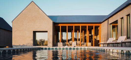 Contemporary home with a stunning pool showcasing a unique, half-circle tiled edge at golden hour.