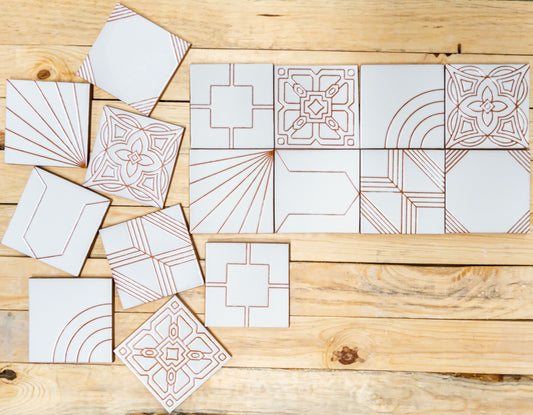 White relief tiles with different patterns laying on a wooden table