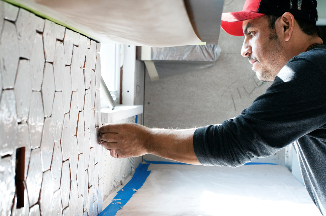 Tile installer putting tile on a wall