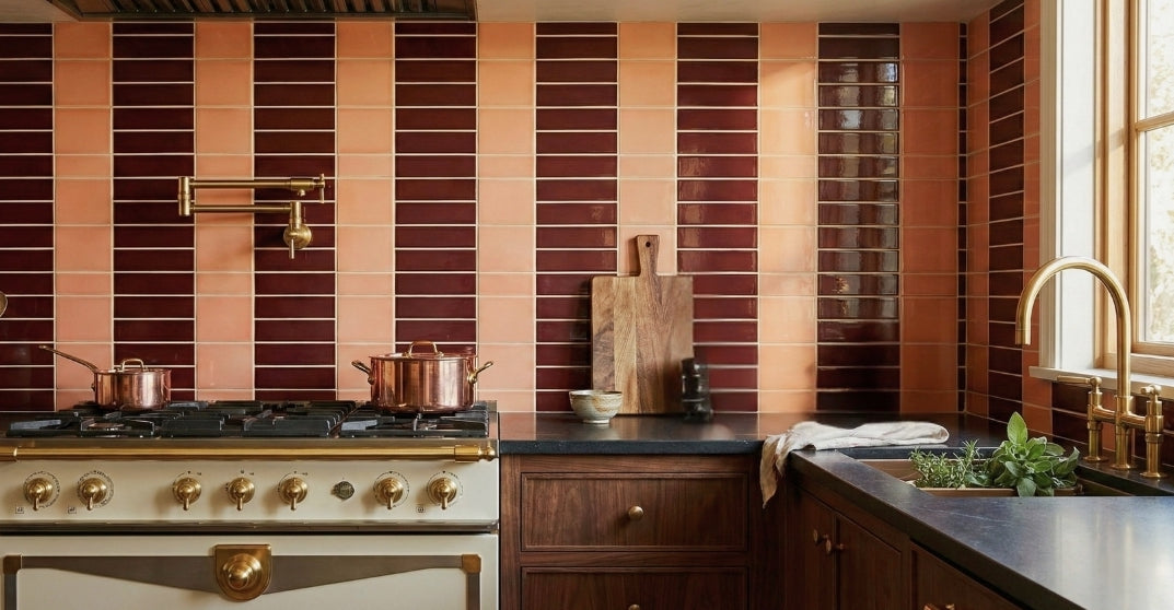Stylish kitchen with a striped peach and burgundy tile backsplash, a cream range, and elegant brass fixtures.