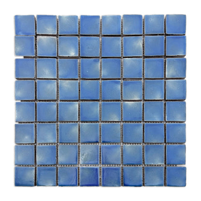 Blue square clay tiles by Clay Imports with varied light and dark shades arranged on a mesh sheet.