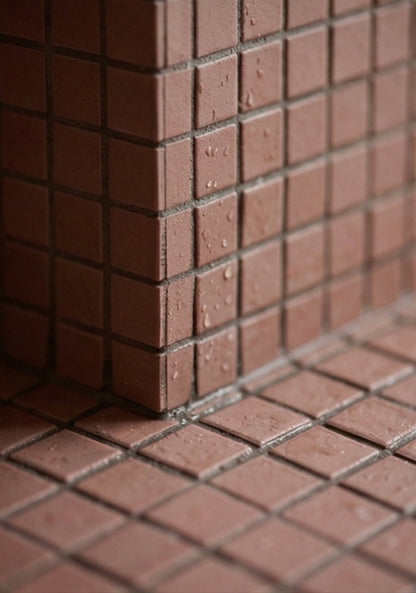 Pink Granite Meshed Clay Tile by Clay Imports forming a textured corner and floor with water droplets.