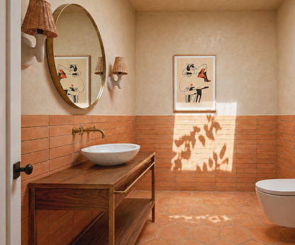 Bathroom interior with wooden vanity, round mirror, and terracotta tiles.
