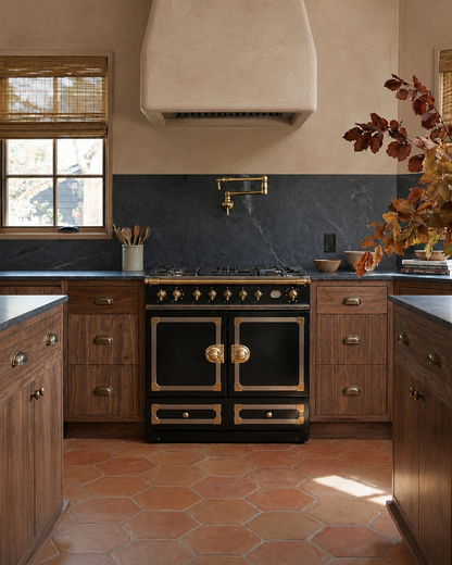 Rounded hexagon terracotta tiles by Clay Imports in earthy reddish-orange tones covering a rustic kitchen floor.