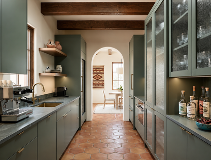 Natural reddish-brown rounded hexagon terracotta floor tiles by Clay Imports in a long galley kitchen.