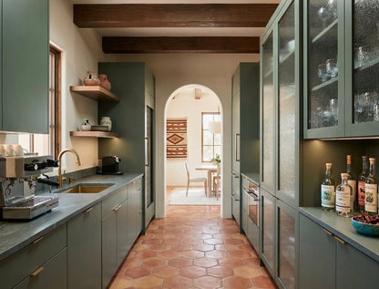 Natural reddish-brown rounded hexagon terracotta floor tiles by Clay Imports in a long galley kitchen.