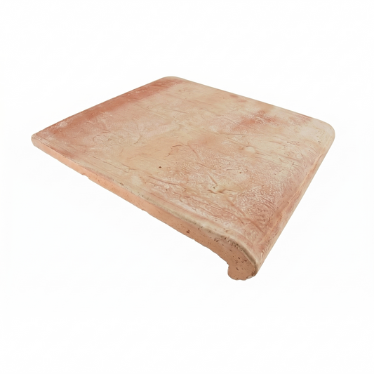 Antique matte terracotta coping tile by Clay Imports, with a textured surface and curved edge.