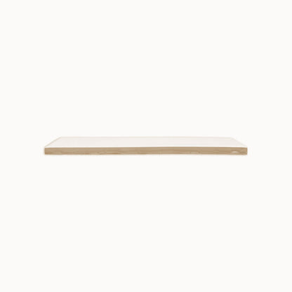 A Fossil Gloss 2x12 solid tile by Clay Imports, displaying its raw beige side from a horizontal view.