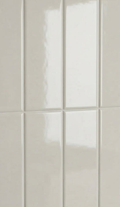 Light beige glossy rectangular clay tiles by Clay Imports, arranged vertically with subtle grout lines.