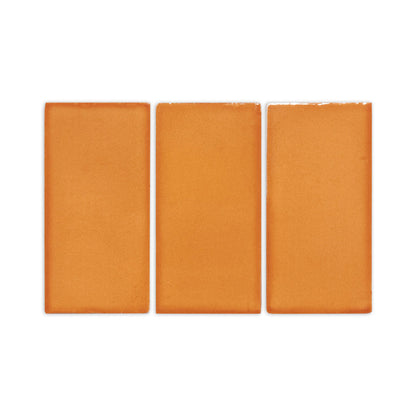Three orange Mandarin 2.25x4.25 clay tiles by Clay Imports, showing rustic texture and slightly uneven edges.
