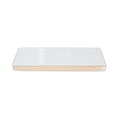 Rectangular Moonstone Gloss tile sample from Clay Imports, showing its shiny white top and beige bisque side.