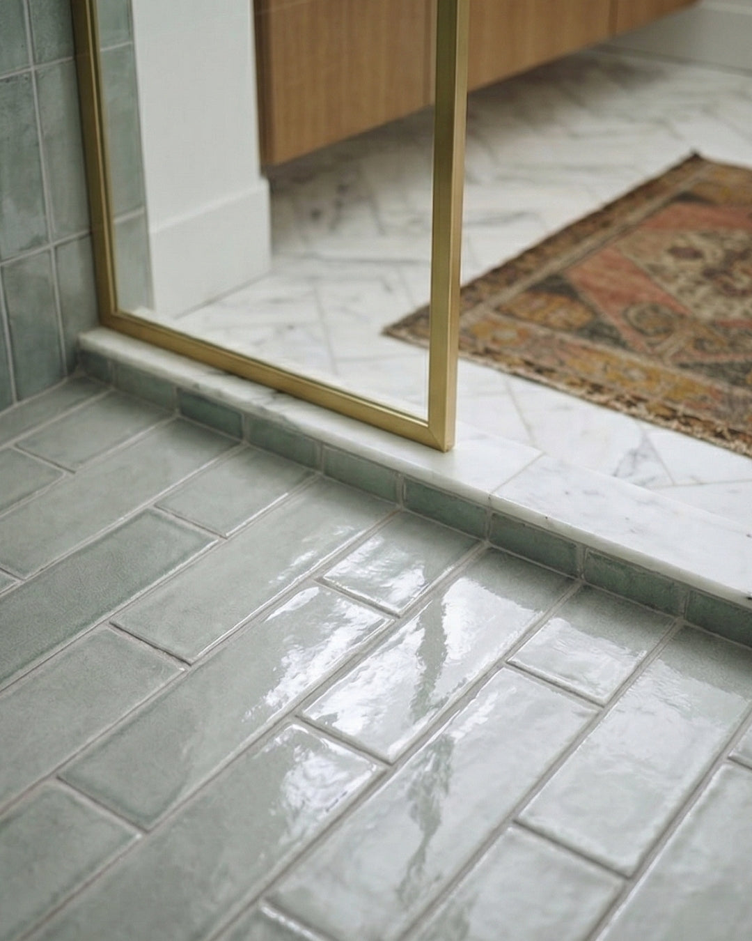 Horizon Arctic Gloss 2x6 tiles by Clay Imports, glossy light green, laid in an offset pattern on a shower floor.