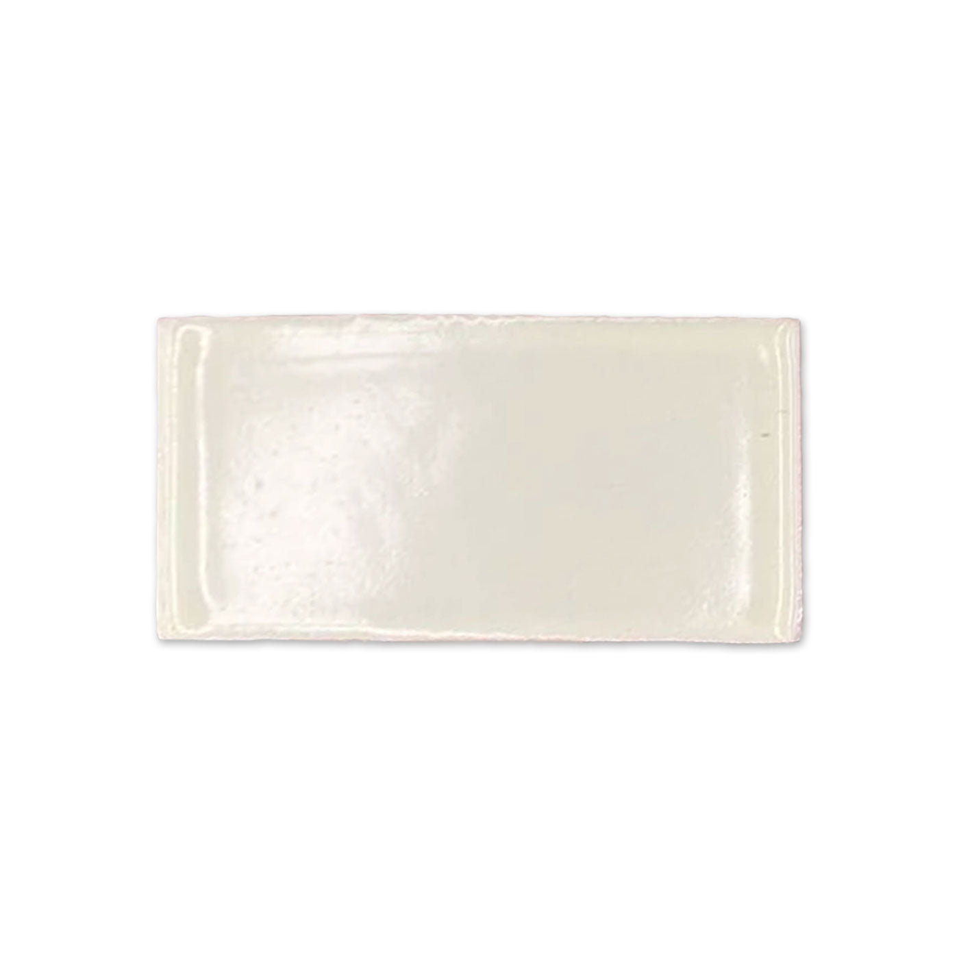 Off-white glossy tile sample by Clay Imports, rectangular with an uneven surface and irregular edges.