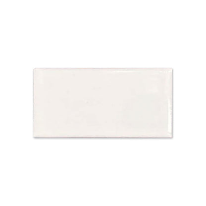 Off-white glossy rectangular tile sample from Clay Imports with subtle surface irregularities.