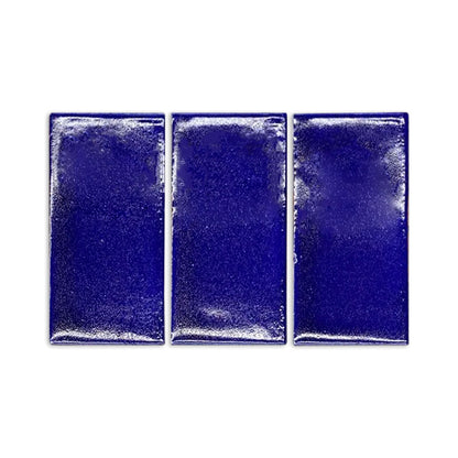 Three rectangular cobalt blue gloss tile samples by Clay Imports with a handmade, slightly textured finish.