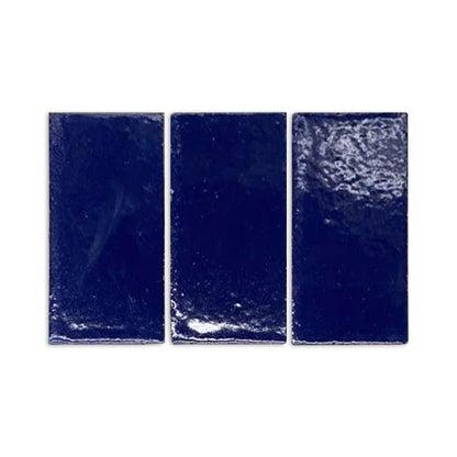 Dark blue glossy sample tiles by Clay Imports with textured, irregular surfaces reflecting light.