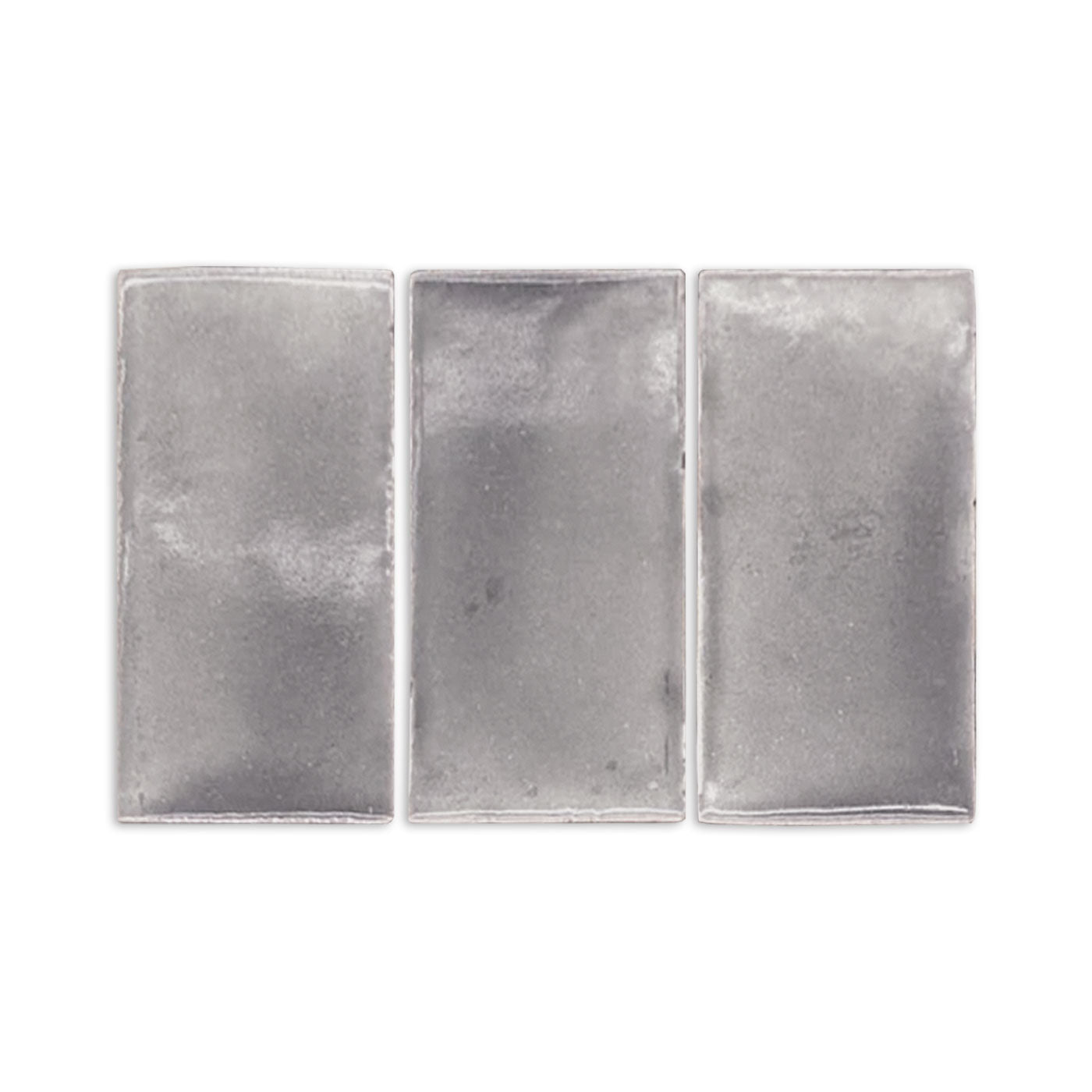 Three graphite gloss tile samples by Clay Imports, rectangular and silver-gray with a subtle textured finish.