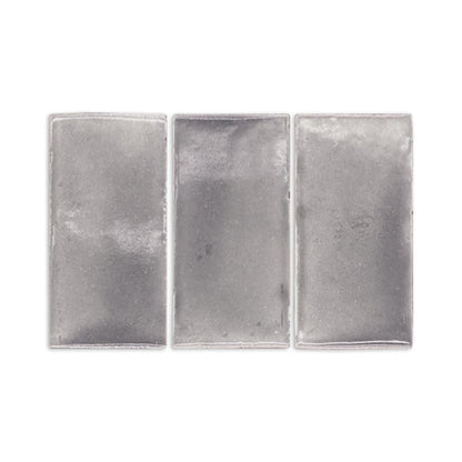 Three graphite gloss tile samples by Clay Imports, rectangular and silver-gray with a subtle textured finish.