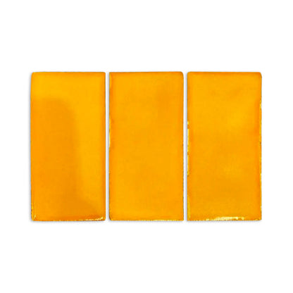 Three mango orange glossy rectangular samples by Clay Imports, with rough edges, displayed side-by-side.
