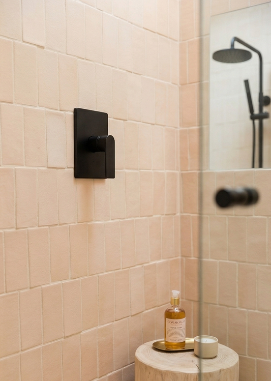 Light peach rectangular clay tile by Clay Imports, installed vertically as shower walls with matte black fixtures.