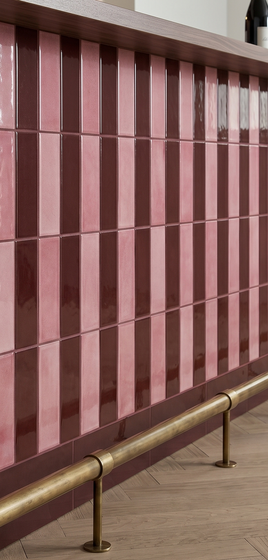 Pink and brown striped tiles with a gold handrail on a wooden floor.