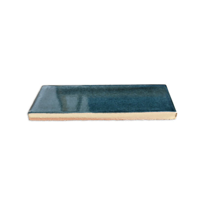 Botanical Teal rectangular clay tile by Clay Imports, with a glossy glaze and visible unglazed side.
