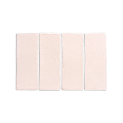 Four pale pinkish-beige matte 2x6 tiles by Clay Imports, with an irregular, handmade surface, laid horizontally.