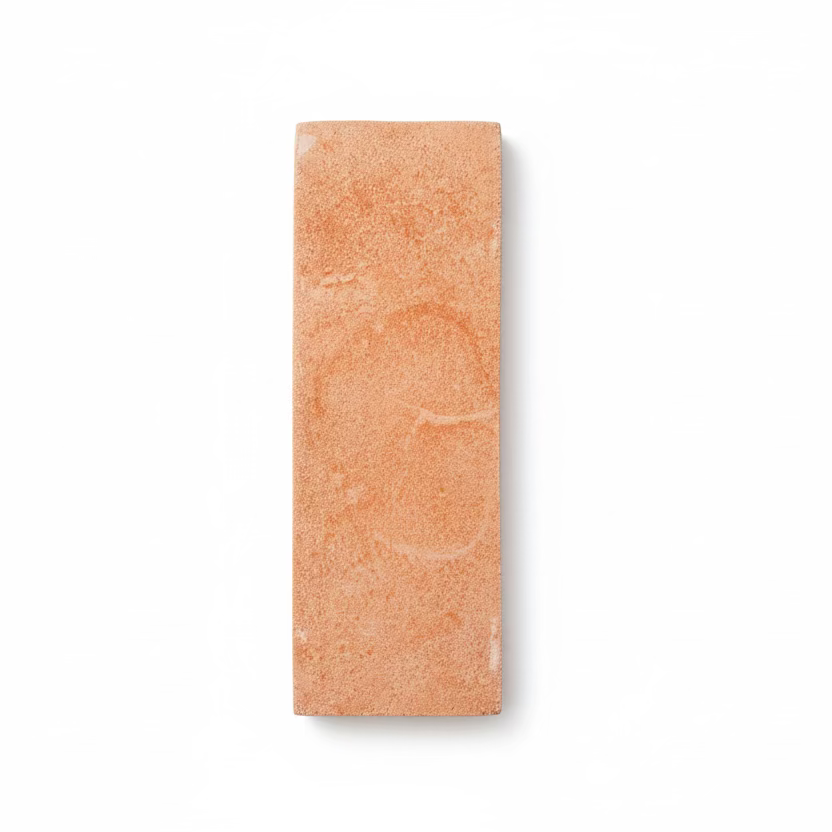 Matte terracotta 2x6 tile sample by Clay Imports, featuring a sandy texture and subtle swirling patterns on a white background.