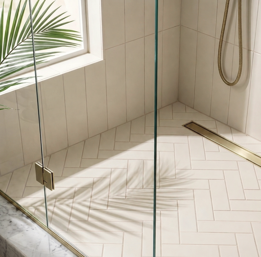 Modern shower with glass enclosure and tiled walls, featuring a palm leaf.