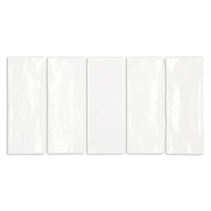 Five white gloss tiles from Clay Imports, rectangular with subtle undulations and slightly irregular edges.