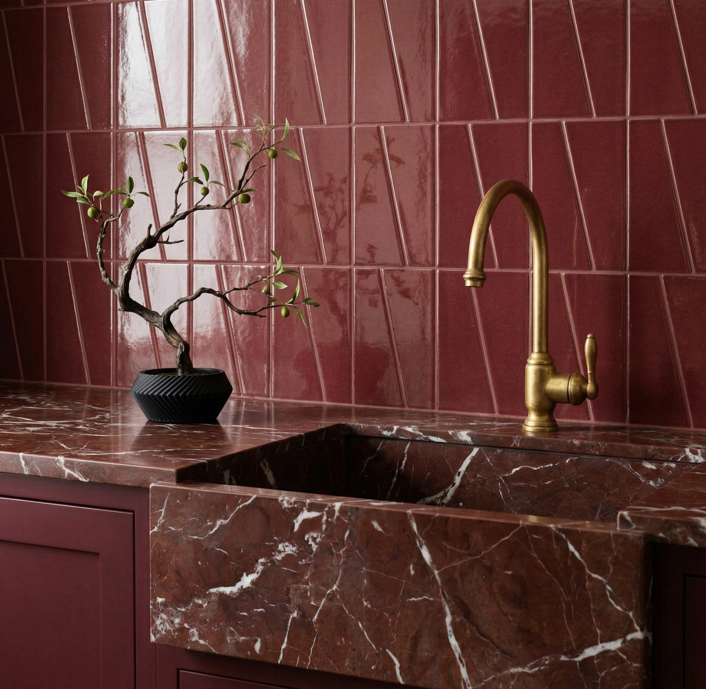 Plum 2x6 clay tiles by Clay Imports, with a glossy finish in a geometric backsplash design above a marble counter.