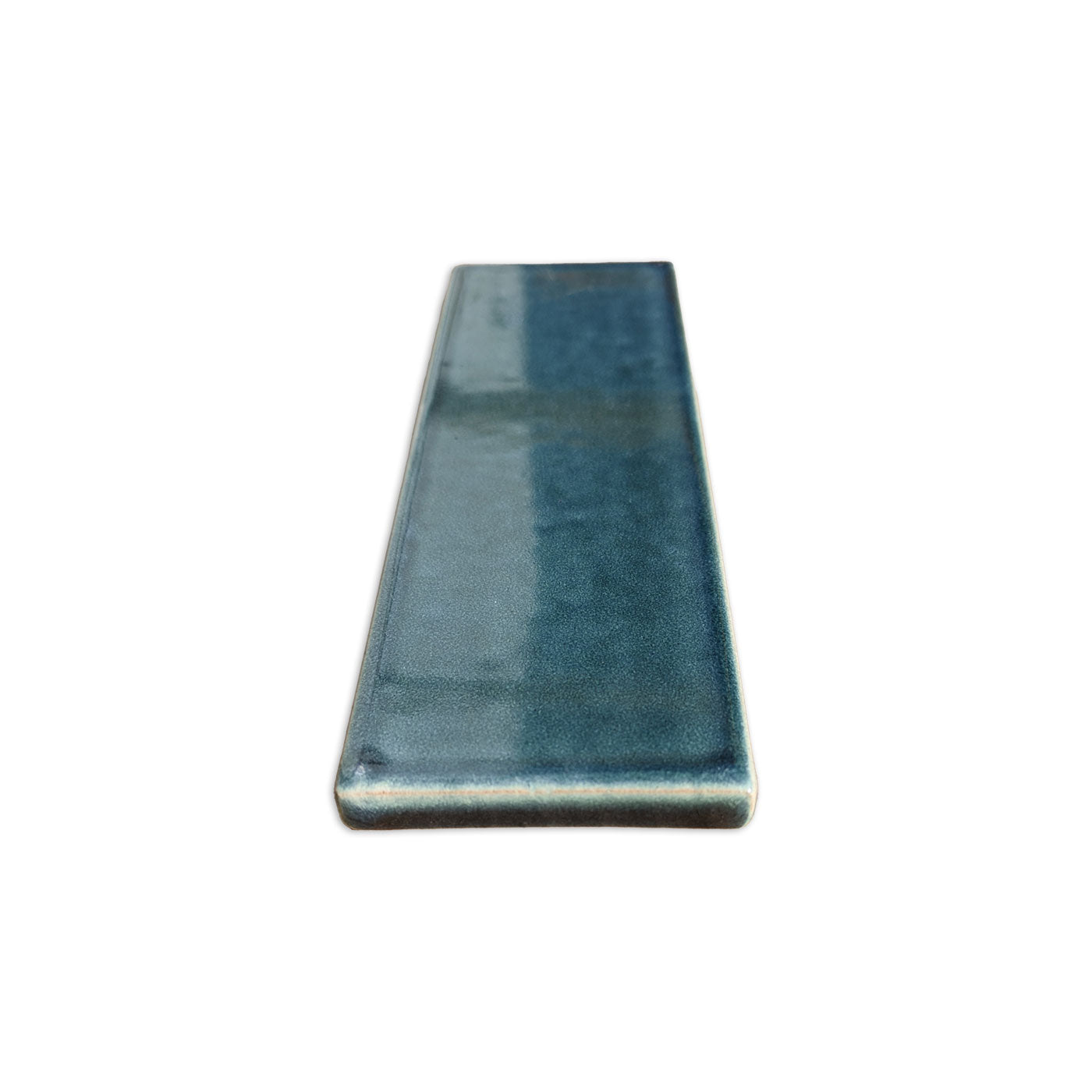 Botanical Teal Solid Tile Trim by Clay Imports, glazed with rounded edges, viewed from the side.