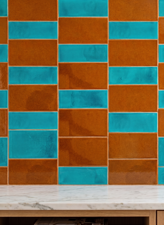Terra and Turquoise crackle glaze rectangular wall tiles by Clay Imports, arranged in an alternating pattern above a white marble countertop.