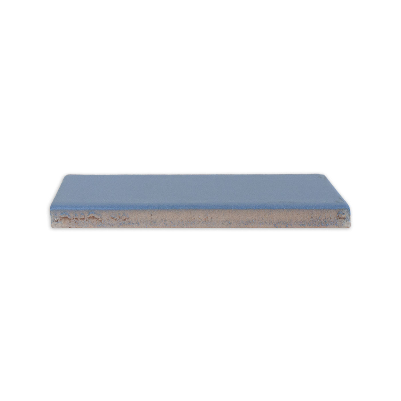 Denim blue clay tile from Clay Imports, in a rectangular shape, seen from the side with rough edges.