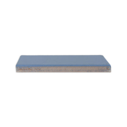 Denim blue clay tile from Clay Imports, in a rectangular shape, seen from the side with rough edges.