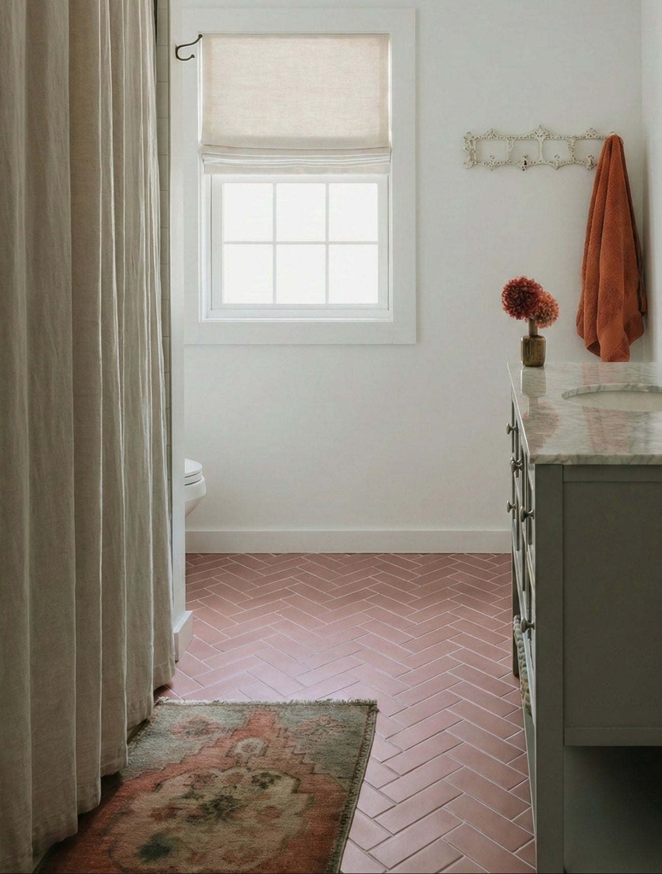 Rosewater Matte Solid Tile by Clay Imports in a herringbone pattern covering a bathroom floor.