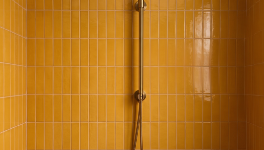 Marigold yellow clay tiles by Clay Imports, vertically stacked in a shower with a brass fixture.