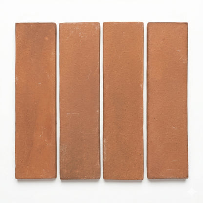 Four umber Cotto 2x8 tiles by Clay Imports, arranged vertically with white gaps, showcasing a matte, textured finish.