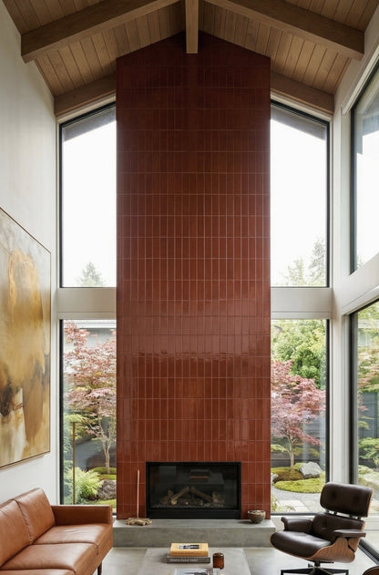 Glossy reddish-brown 2x5 solid tiles by Clay Imports, vertically arranged on a tall fireplace accent wall.