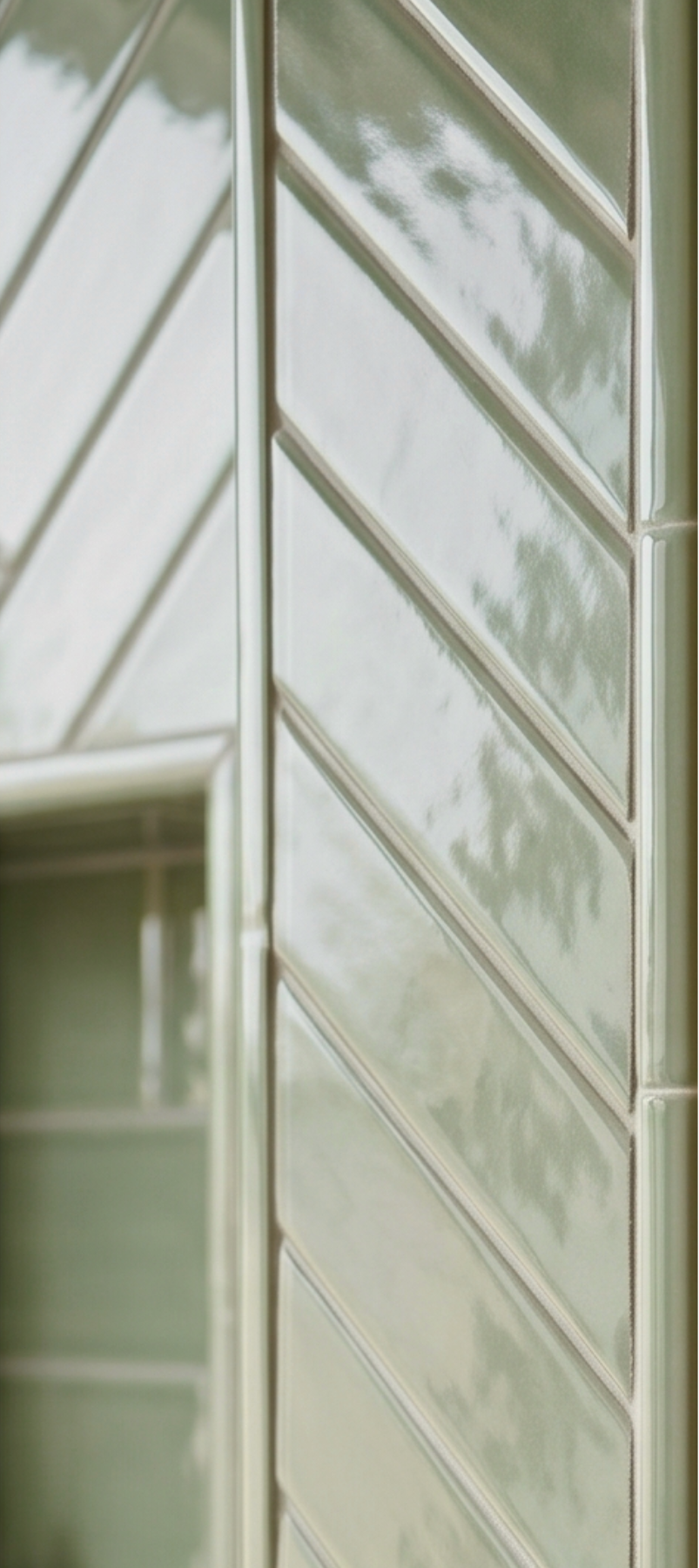 Glossy sage green solid tile by Clay Imports, featuring a chevron pattern with raised edges in a close-up view.