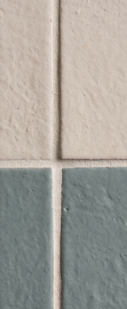 Glazed Thin Brick in Rucksack Green, 2.5x8, by Clay Imports, displaying a textured finish, with light grout and beige tiles.
