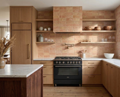 Antique matte terracotta thin brick by Clay Imports used as a warm peach kitchen backsplash with light wood cabinets.