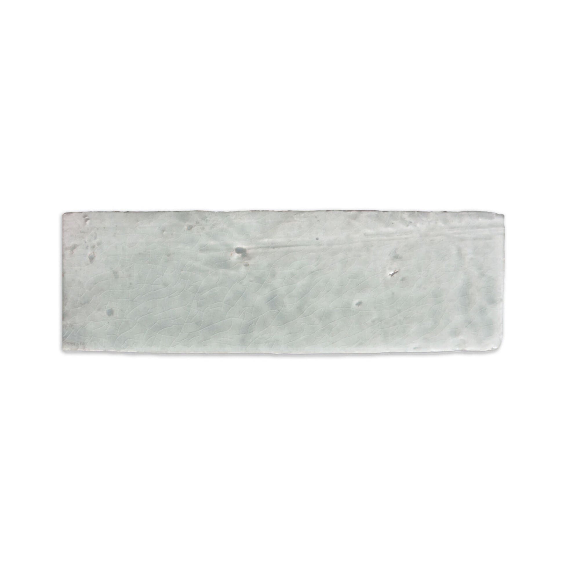 Light grey glazed thin brick by Clay Imports with a crackled texture and irregular edges.