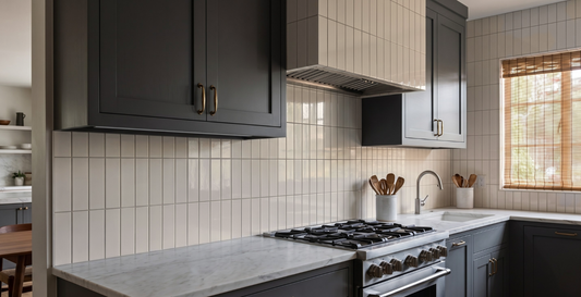 Creamy white glossy vertical subway tile by Clay Imports installed as a kitchen backsplash.