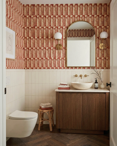Cream vertical solid tile by Clay Imports, forming a wainscoting below red patterned wallpaper in a bathroom.
