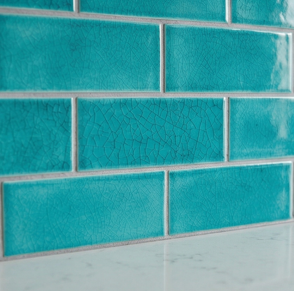 Turquoise crackle clay subway tiles by Clay Imports, arranged in a brick pattern above a white counter.