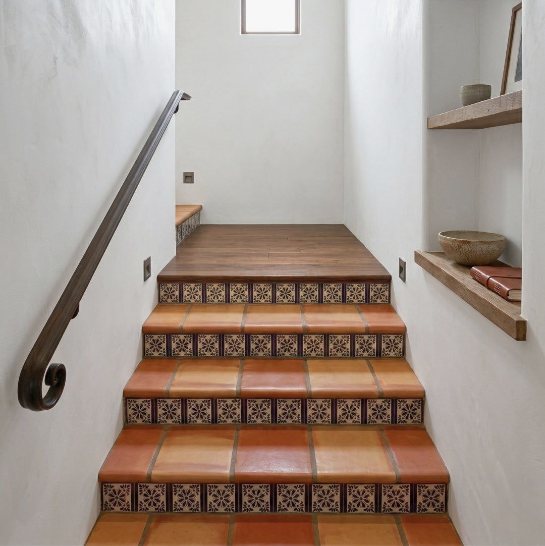 Terracotta and patterned floral Talavera tiles by Clay Imports installed on a staircase's treads and risers.
