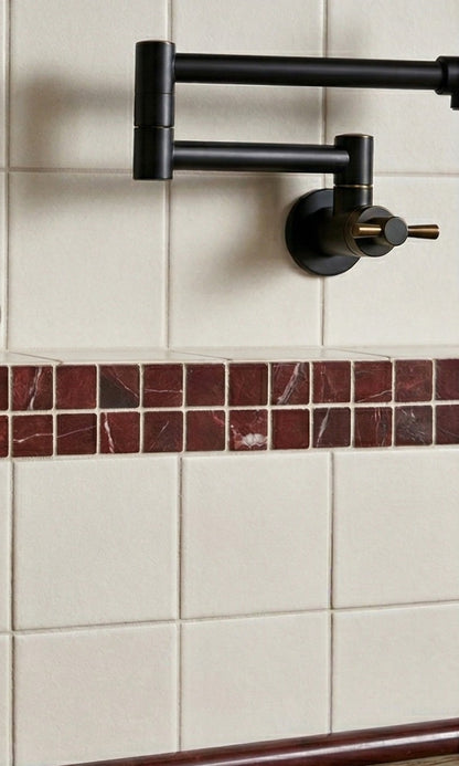 Off-white square 4.25x4.25 clay tiles by Clay Imports on a wall, with a dark pot filler and red marble-look border.